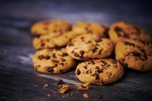 galletas de chocolate tumbadas una al lado de la otra sobre fondo de madera foto