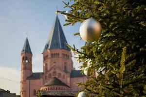 sharp in front is a christmas tree, in the background blurred is the Mainzer Dom, the cathedral of Mainz, Germany photo