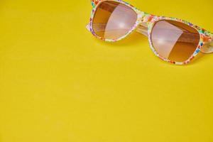 summer background with sun glasses on yellow background photo