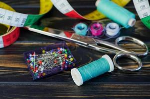 close up color photo of different sewing equipment against wooden background