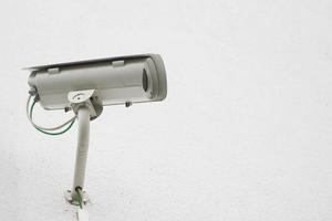 close up of a surveillance camera against a white wall with copy space photo