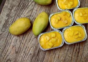 mango cake in foil cup on wooden table photo