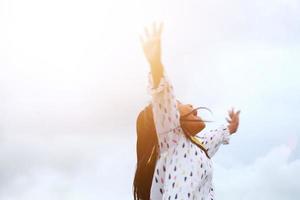 Close up happy little girl in colorful dress jumping and laughing hard with sunlight effect. Felling freedom. Blurred concept. photo