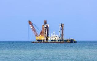 el barco de dragado está arrojando lodo en la costa para mantener el nivel del agua para el transporte de grandes embarcaciones mientras destruye el hábitat marino en la costa foto