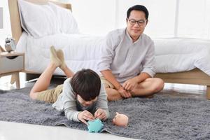 Asian father is teaching his son the saving lesson for investment in education and future planning photo