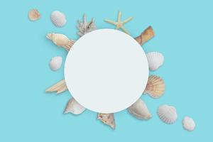 White round paper surrounded by shells. Summer travel background photo