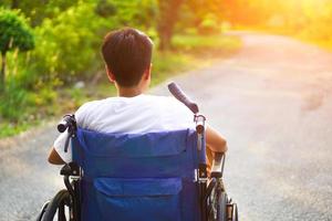 pacientes o discapacitados sentados en una silla de ruedas mirando hacia adelante con esperanza. concepto médico y de salud. foto
