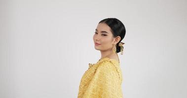 retrato de mulher tailandesa em traje tradicional, olhando para a câmera e sorrindo com fundo branco isolado.