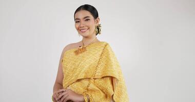 portrait de femme thaïlandaise salut de respect en costume traditionnel de thaïlande. jeune femme regardant la caméra et souriant avec fond blanc isolé. video