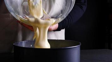 Chef pouring cream cake into mold container before putting to the oven - people preparing homemade bakery concept video