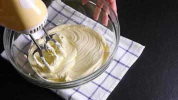 la señora está haciendo pastel de crema usando una máquina mezcladora portátil eléctrica video