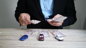 el hombre de negocios está contando dinero en efectivo para el pago de sus autos