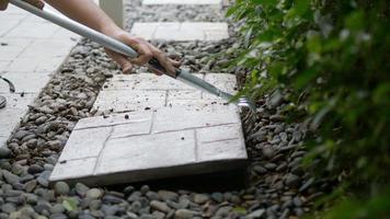 el jardinero está trabajando con la decoración del suelo del jardín doméstico utilizando losas de hormigón y material de piedra video