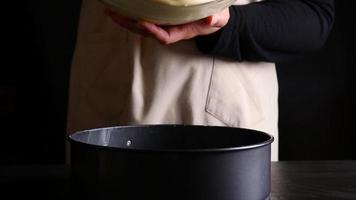 Chef pouring cream cake into mold container before putting to the oven - people preparing homemade bakery concept video