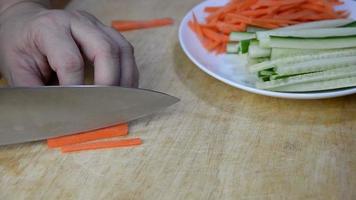 Chef cutting carrot vegetable for making sushi - people with favorite dish Japanese food concept video