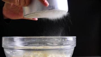 Lady screening flour while preparing homemade cake bakery recipe video