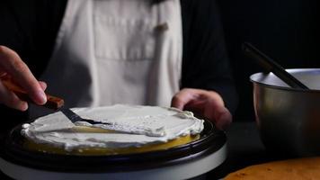 la signora ha messo la crema sopra la torta usando la spatola - persone con il concetto di panetteria fatta in casa video