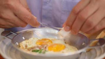 Man is eating bread with fried egg pan, people at hotel breakfast restaurant video