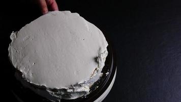 vista dall'alto dello chef mettere la crema sulla torta usando la spatola - persone con il concetto di panetteria fatta in casa video