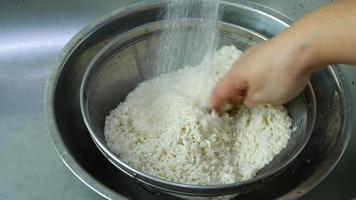 senhora está limpando arroz cru se preparando para cozinhar video
