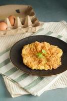 Thai-style Egg Omelette, isolated served in a white plate with coriander leaves as garnish.Thai Asian style food. Copy space photo