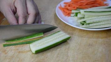 Chef cutting cucumber vegetable for making sushi - people with favorite dish Japanese food concept video