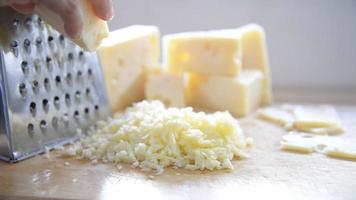 frau, die käse für koch mit käsereibe in der küche zubereitet - leute, die lebensmittel mit käsekonzept zubereiten video