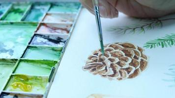 Lady is drawing pinecone using watercolor - people with Christmas celebration art hand draw watercolor concept video