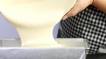 chef vertiendo crema de pastel de mantequilla en un recipiente de molde antes de ponerlo en el horno - gente preparando el concepto de panadería casera video
