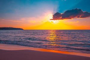hermosa puesta de sol en la playa tropical con cielo y nubes para viajar en vacaciones relajarse foto