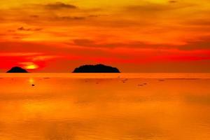 paisajes marinos de hermosa puesta de sol en la playa del mar con nubes, cielo naranja de vacaciones foto