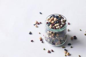 mixed beans in a glass jar on table photo