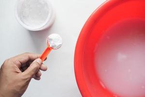 holding a plastic spoon with a washing powder top view photo