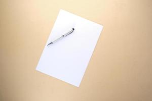 top view of empty paper and a pen on table photo