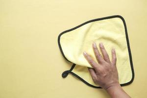 top view of person hand cleaning table with yellow cloth photo