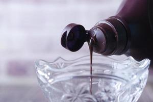 dark chocolate cream pouring from a bottle photo
