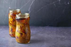 Homemade Mango Pickle in a glass jar on table , photo