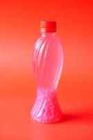 plastic bottles of soft drink on red background photo