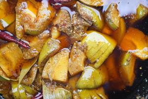 Homemade Mango Pickle in a glass jar on table , photo