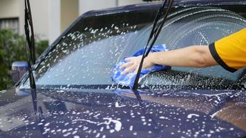 El hombre lava el coche con champú - concepto de cuidado del coche de la vida cotidiana video
