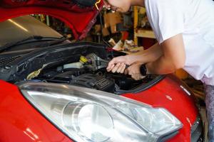 mecánico de automóviles trabajando en garaje. servicio de reparación, concepto de revisión de automóviles foto