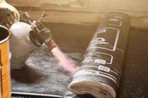 installation of waterproofing coating on the floor with a blowtorch and resin. photo