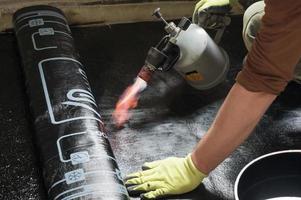 installation of waterproofing coating on the floor with a blowtorch and resin. photo