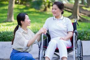 Young Asian daughter taking care of her disabled mother photo