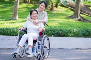 Young Asian daughter taking care of her disabled mother photo