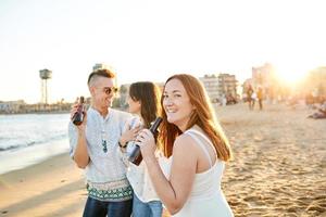 Friends drinking beer on the beach photo