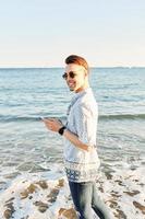 un hombre hablando por teléfono en la playa foto