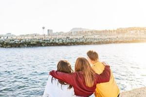 Friends with their backs to each other and hugging photo