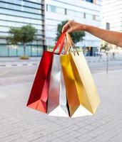 Vertical shot of a person carrying colorful shopping bags photo