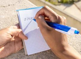 Person writing down her new ideas in a notebook photo